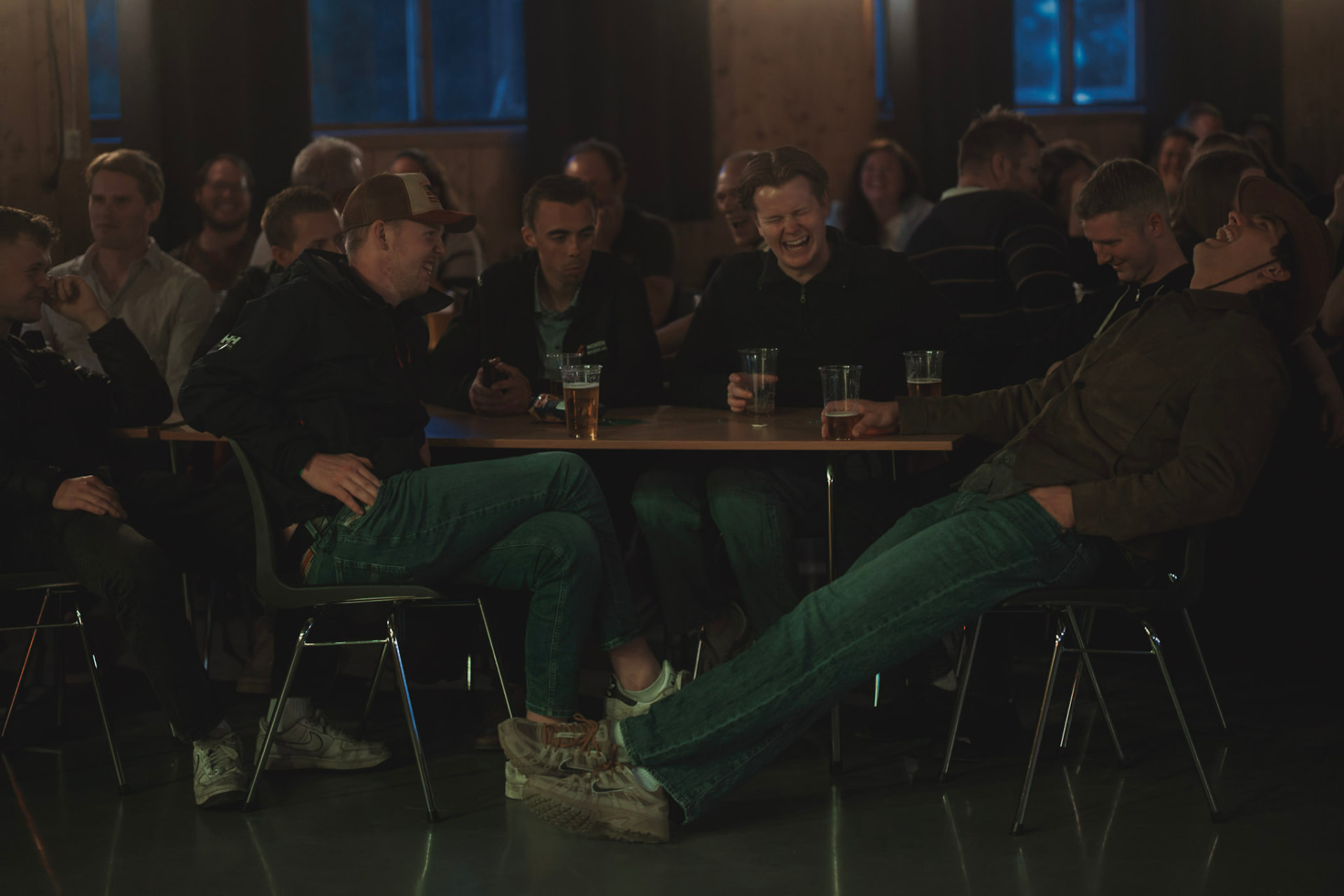 Kollegaer ler rundt bordet på en festkveld